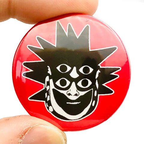 Black and white portrait of Leigh Bowery on a red background on a 1 1/2” round pinback button