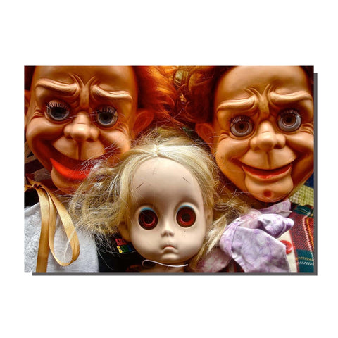 A note card featuring a photograph of three creepy dolls shown in close-up
