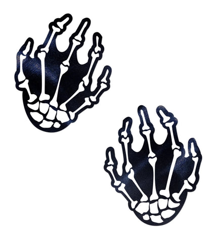 A pair of black and white skeleton hand shaped pasties