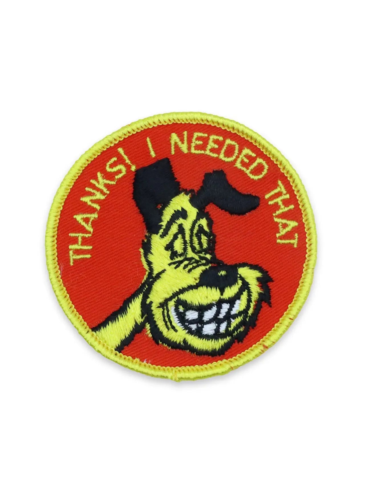 Deadstock round embroidered patch with an illustration of a smiling cartoon dog and the caption “THANKS! I NEEDED THAT” on a red background with yellow type