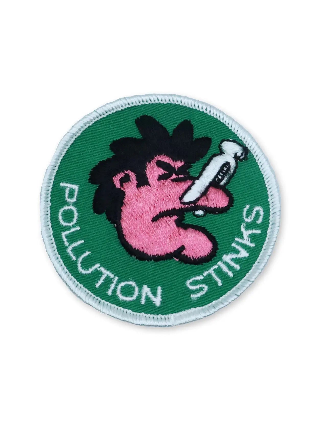 Round deadstock embroidered patch with a cartoon of someone holding their nose closed with a clothespin and the message “POLLUTION STINKS”. On a green background with a white border 