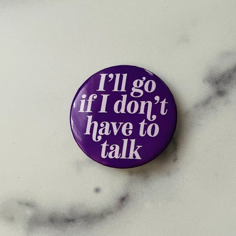 Round 2 1/4” button with dark purple background and “I’ll Go If I Don’t Have to Talk” in light purple font