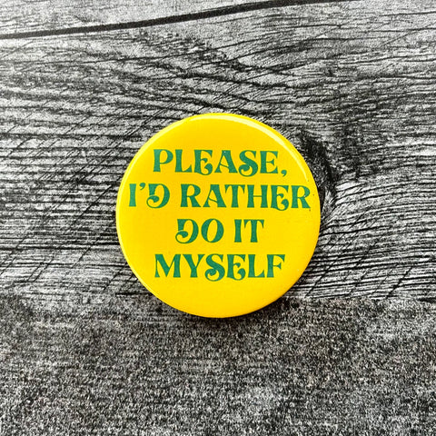 2 1/4” round button with bright yellow background and “Please, I’d Rather Do It Myself” written in green script