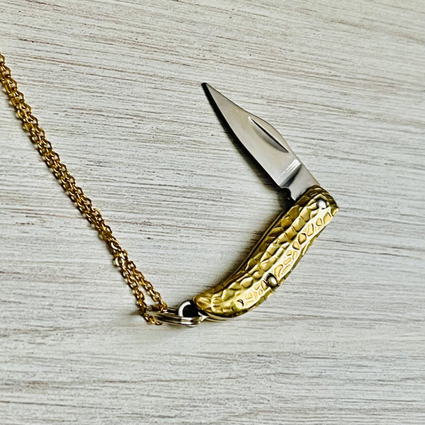 Gold tone brass chain link necklace with a gold tone peanut-shaped charm that has a fold out blade. Shown opened