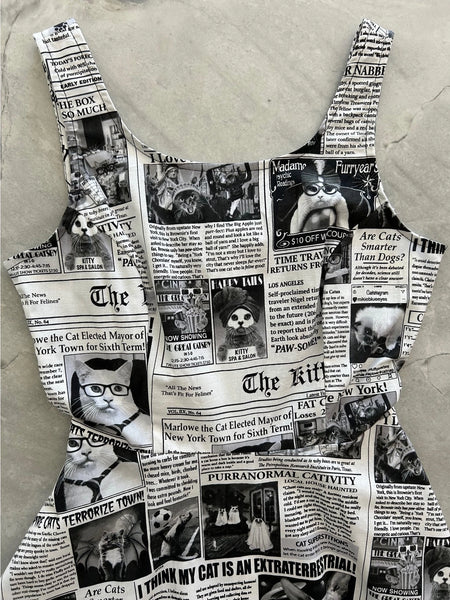 Cotton sleeveless skater style minidress with princess seaming and scoop neck. It has an all over black and white newspaper pattern themed to cats. Bodice shown in close up