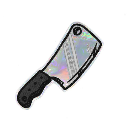 Embroidered patch in the shape of a cleaver with silver holographic vinyl for the blade and a grey and black embroidered handle  
