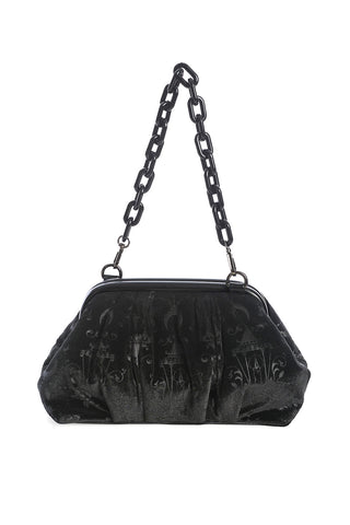 Black velvet purse with embossed damask pattern of chandeliers, candles, crescent moons, and roses. Has a black plastic chain link shoulder strap and faux leather hinge detail on the exterior. Shown from the side