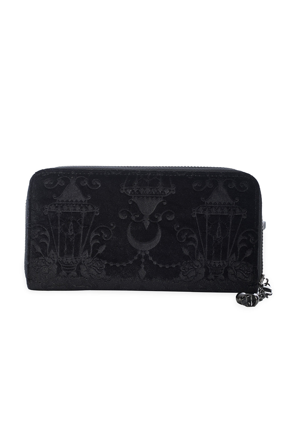 Zippered wallet with black velvet exterior that has an embossed damask pattern of chandeliers, candles, roses, and crescent moons. It has gunmetal tone hardware with a skull shaped charm attached to the zipper. Seen closed from the side