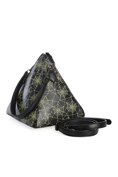 Pyramid shaped purse with all over glow in the dark cobweb printed pattern. It has a matching black faux leather shoulder strap and there are two vertical black zippers running down the side of the pyramid. Shown from the side with crossbody strap