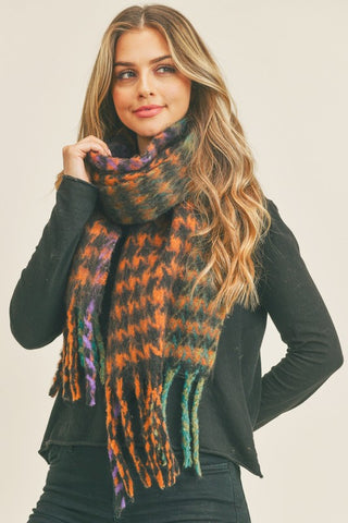 chunky knit black and purple, orange, green, and teal tasseled scarf with a houndstooth pattern
