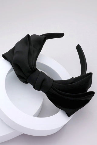 Black satin style fabric bow attached to matching fabric wrapped headband