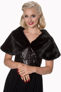 Model wearing a black faux fur shawl with black ribbon tie closure. Seen from the front