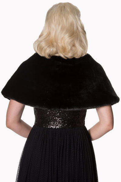 Model wearing a black faux fur shawl with black ribbon tie closure. Seen from the back