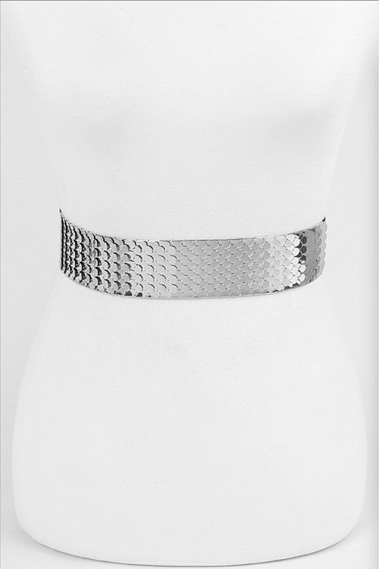 Waist belt made of articulated silver metal panels with a scalloped edge and black elastic, shown on a dress form from the front 
