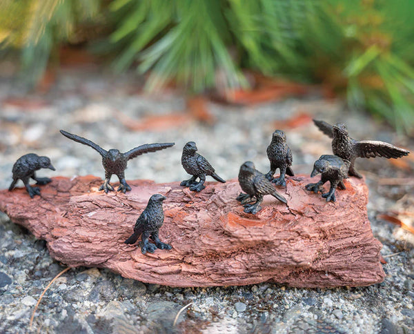 12 itty bitty soft vinyl black crows in various poses seen on a log