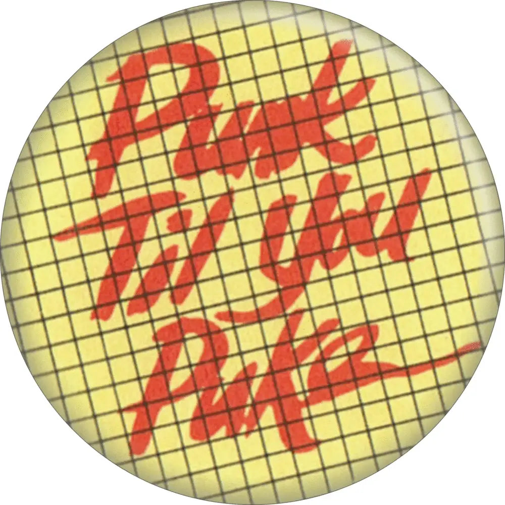 1.5” round pinback button with black grid on pale yellow background with “Punk Til You Puke” in red cursive