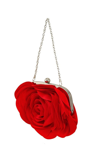 Purse made of a shiny satiny bright red fabric with layers of petal shapes sewn onto the body of the bag to resemble a rose. Silver metal hardware with a kiss lock and silver metal link chain strap.  Shown from a three quarter angle