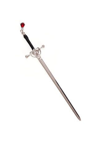Silver metal hair stick in the shape of a sword with orange silver and black handle and red glass bead in the shape of a drop of blood at the end of the handle. Shown flat 