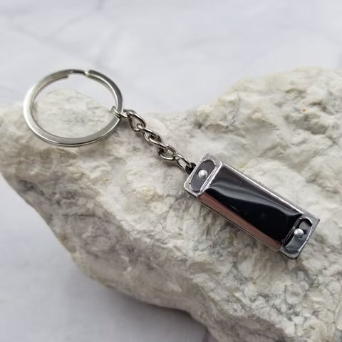Silver metal harmonica charm on a split keychain ring