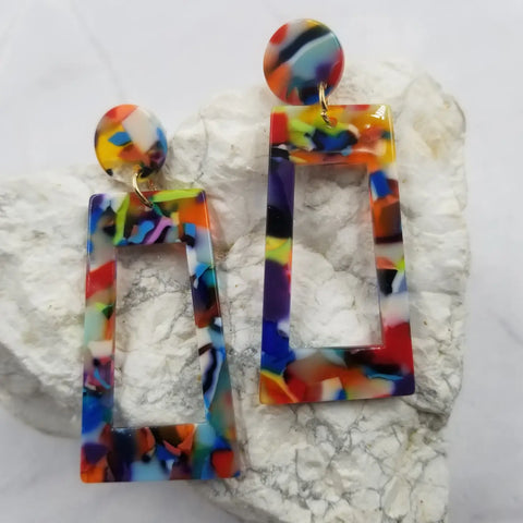 Multicolored confetti style acetate drop earrings in an asymmetrical rectangle shape with a round charm attaching to the ear