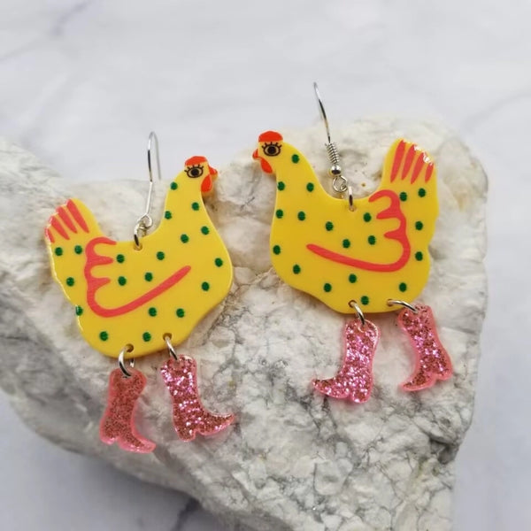 Yellow chicken with green dots and red details wearing pink glitter cowboy boots acrylic dangle earrings 