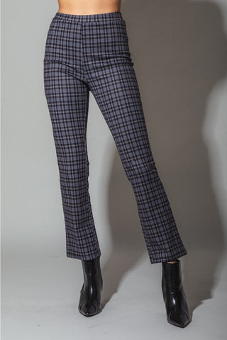 A model wearing high waisted black, white, and blue-ish plaid bootcut pants. Shown from the front