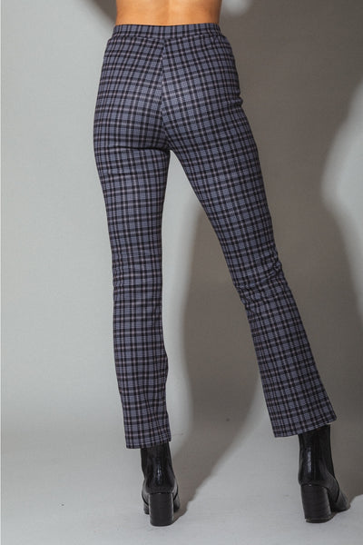 A model wearing high waisted black, white, and blue-ish plaid bootcut pants. Shown from the back