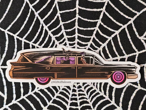 Die-cut sticker of a black hearse with orange detail, pink-curtained windows and tires, and a skeleton in a chauffeur’s hat in the passenger seat. Shown on a spiderweb background 
