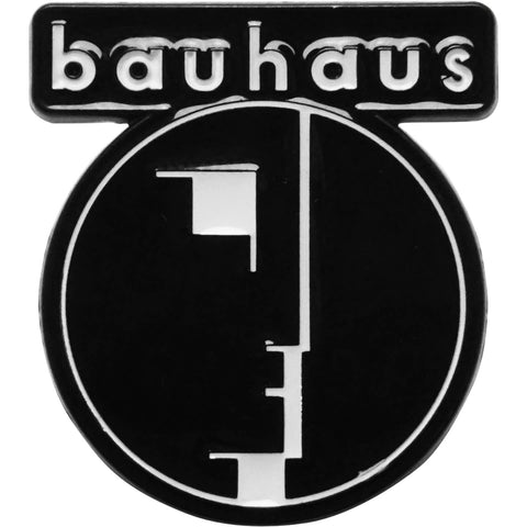 Shiny black and white metal enamel pin of round Bauhaus logo and band name. Shown from front