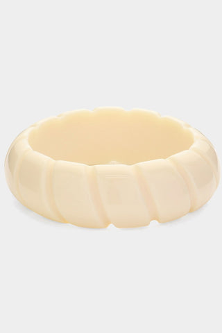 Shiny round resin bangle in ivory with a diagonal indented pattern