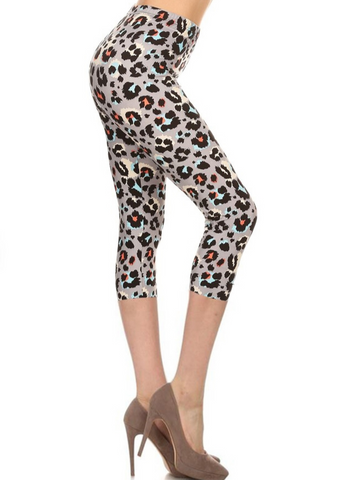 High-waist leggings in a black, white, grey, bright blue, and coral leopard print. Shown on a model from a side angle