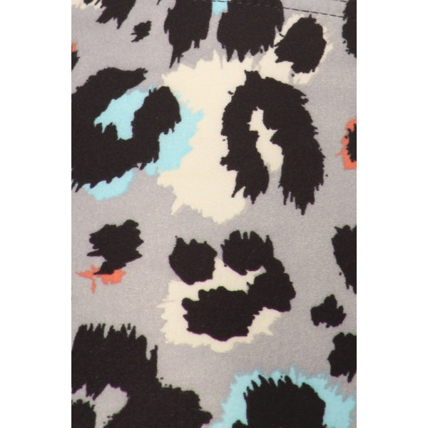 High-waist leggings in a black, white, grey, bright blue, and coral leopard print. Shown in close up of print detail