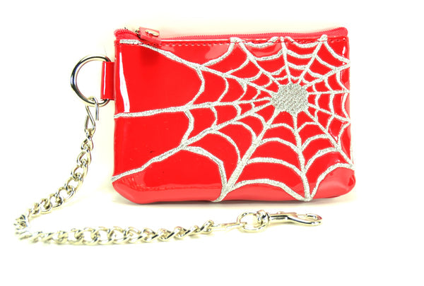 Red rectangular vinyl zippered coin purse with silver metallic thread stitched spiderweb detail off center. Has attached D-ring with 6” chain. Shown with chain