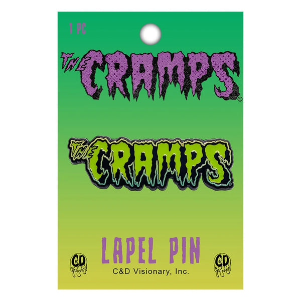 The Cramps lapel pin on its original green gradient backing card, featuring the band's logo in purple and green.