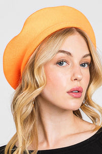 French style acrylic beret in neon orange, shown on a model