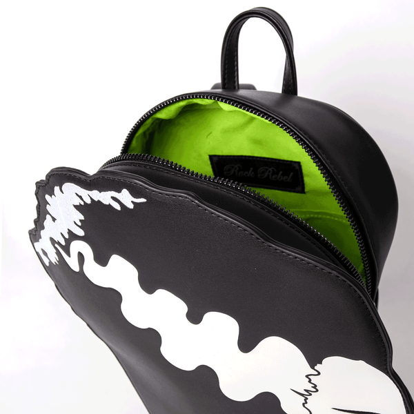 Black faux leather backpack with design of Bride of Frankenstein side profile printed with embroidered lips, facial features, and hair detail. Shown open from top to display bright green fabric interior and hand strap