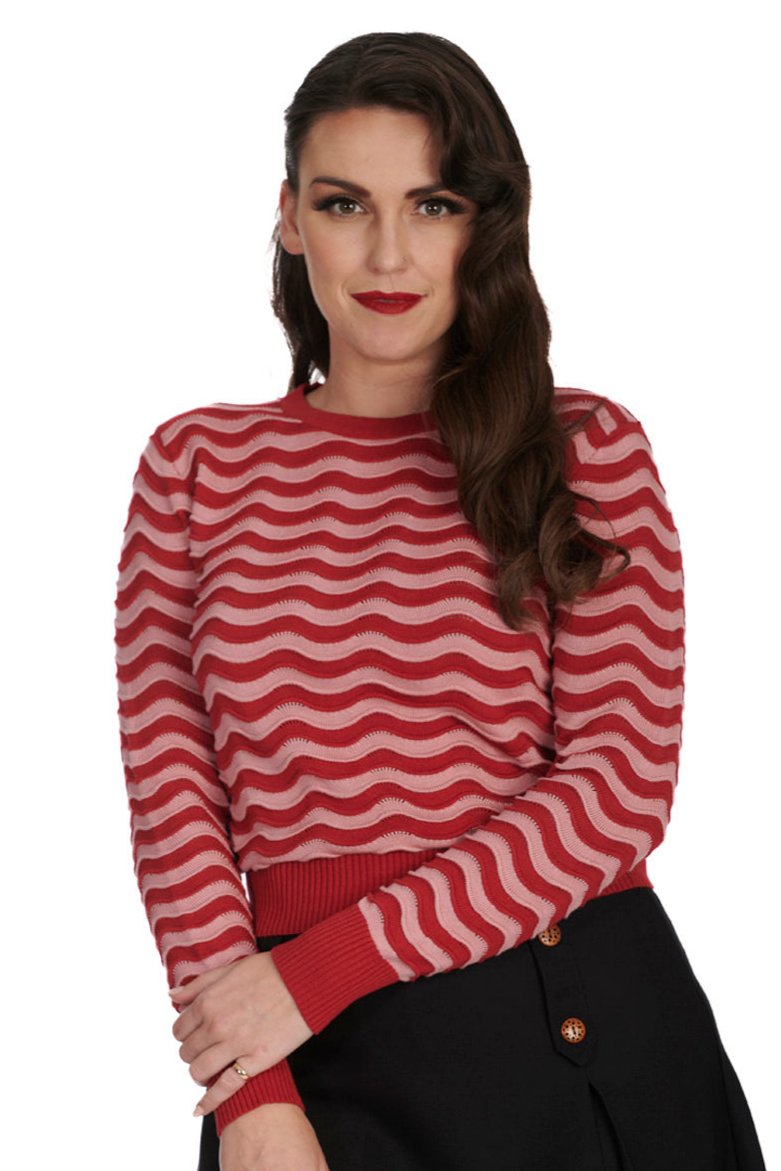 Model wearing a long sleeved pullover sweater with a wavy striped pattern in pink and muted red with pointelle detail along the stripes. Red ribbed cuffs and neckline. Shown from front