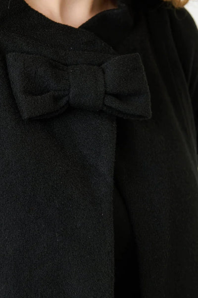 close up of bow detail at neck on black coat