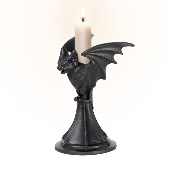 Black resin taper style candleholder in the shape of a highly detailed vampire bat with open mouth and outstretched wings. Shown with lit candle from a three quarter angle