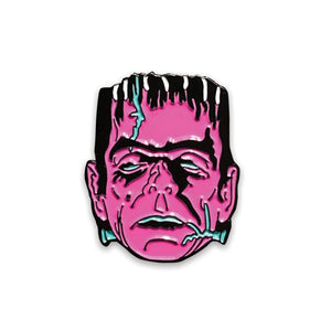 stylized rendering of Boris Karloff as Frankenstein’s monster as a black & neon purple and teal enameled pin with both shiny and matte finish