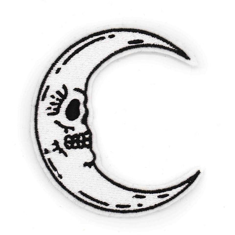 white felt embroidered patch of a bright white crescent moon with a skull face and black outline & highlights