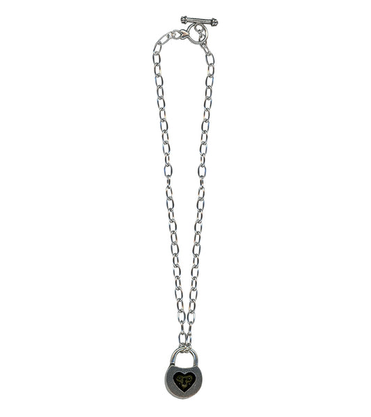 Silver metal toggle chain necklace with pewter padlock charm with inner black heart detail. Shown flat