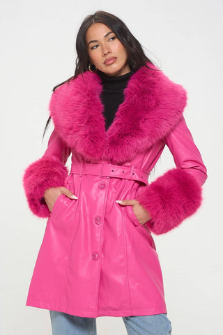 Model wearing hot pink faux fur trench coat with oversized hot pink faux fur shawl collar and wide cuffs. Shown buttoned up from front