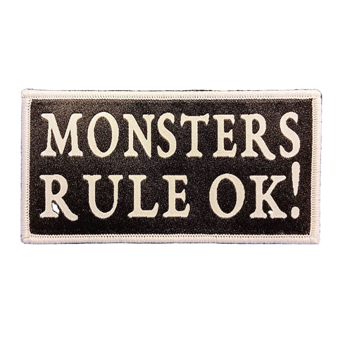 Rectangular woven patch with "MONSTERS RULE OK!" white text on a black background with white trim