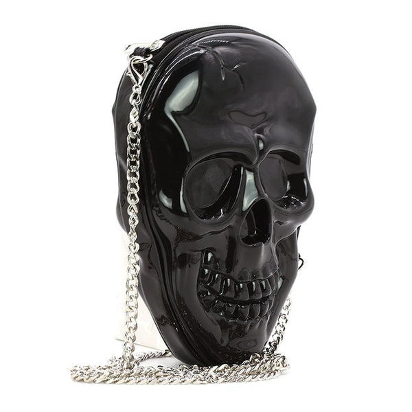 Black moulded plastic crossbody purse in the shape of a smiling skull with top zip closure and  28” silver metal curb chain strap. Shown from side