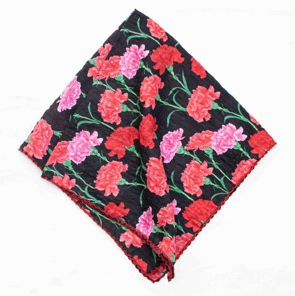 cotton blend seersucker square scarf in black background and pink & red carnation flower pattern with red scalloped embroidered trim. Shown folded