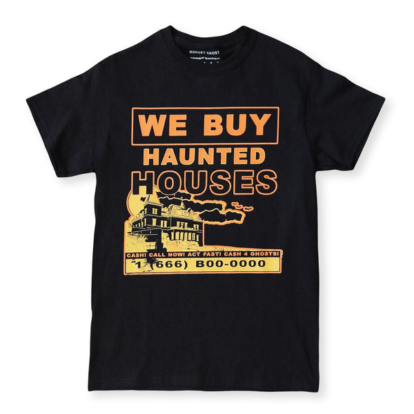 A black short-sleeve t-shirt with a vintage-sign style orange and yellow graphic that reads 'WE BUY HAUNTED HOUSES' above an illustration of a house and contact information: "CA$H! CALL NOW! ACT FAST! CASH FOR GHOSTS! 1 (666) B00-0000”