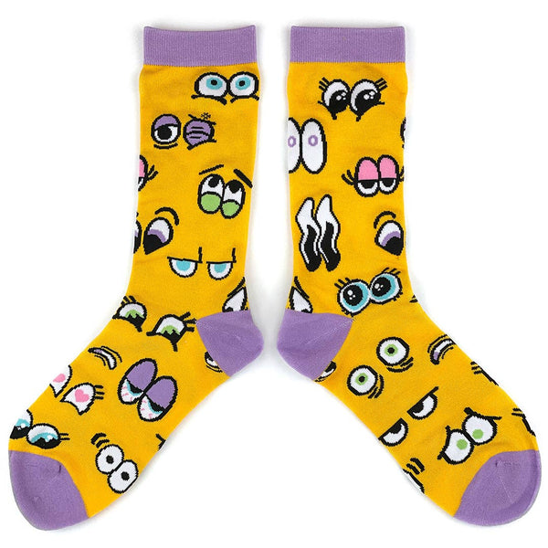 Crew socks with sets of cartoon eyes on a golden yellow background with lavender cuffs, heels, and toes. Shown flat displaying both sides of sock 