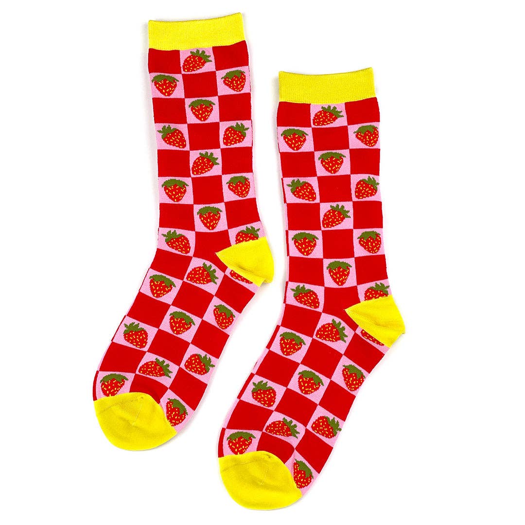 Crew socks with a knit-in pattern of strawberries on a pink and red checkered background with bright yellow cuffs, toes, and heels. Shown flat