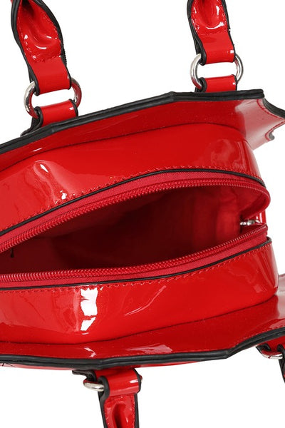 Cherry red patent vinyl handbag in the shape of a scalloped coffin with a black bow detail, hand strap, and black spiderweb patterned stitching. Shown unzipped from top